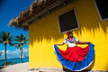 Catalina Island, Dominican Republic. A woman in traditional outfit in front of a bungalow on a seashore (full length portrait).jpg