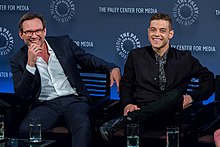 Series stars Christian Slater (left) and Rami Malek (right) speaking as part of the Mr. Robot panel during the 2015 PaleyFest. Slater has also served as a producer since the first season, while Malek began producing in season 3. Christian Slater & Rami Malek in 2015.jpg