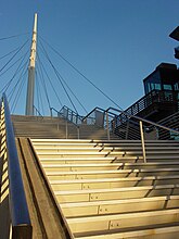 Stairs and a glass elevator lead pedestrians to the landing of Denver's Millennium Bridge. Denver millennium bridge2.jpg