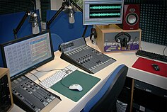 Echos primäres Radiostudio mit Mikrofonen, Computern und einem Audiomischpult.