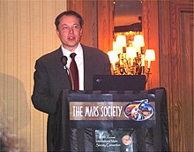 Musk standing at a wooden podium talking at the 2006 Mars Society Conference