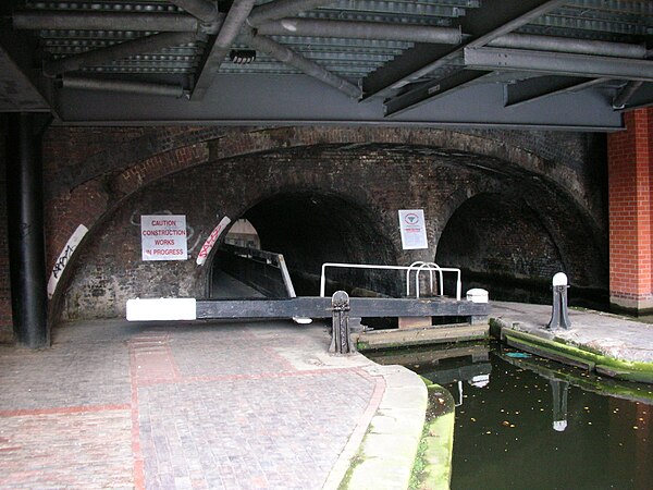 Farmer's Bridge Lock 9 and extended pound, running through two arches of the Newhall Street bridge in central Birmingham. There is a lock gate on eith