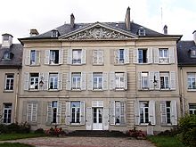 Façade sud en pierre de taille de l’hôtel de ville surmontée d’un fronton triangulaire.