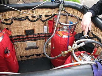 Stainless steel fuel tanks, wrapped in red insulating covers, mounted vertically, and with fuel gauges, during refueling Hot air balloon fuel tanks.jpg
