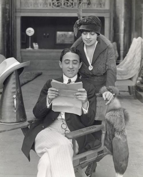 Emerson and Anita Loos examine a script on a film set, 1918.