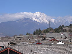 Blick über die Dächer von Lijiang auf den Yulong Xueshan (玉龙雪山 – „Jadedrachen-Schneeberg“, 5596 Meter)