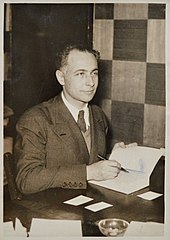 Louis Aragon dédicaçant Les Beaux Quartiers à l'occasion de la remise du prix Renaudot (9 décembre 1936), photo d'Henri Manuel.