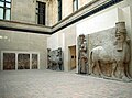 Gevleugelde stieren met mensenhoofd, beeld en reliëfs uit Khorsabad, let op de Lamassu op de voorgrond, dit is een replica uit het Oriental Institute in Chicago