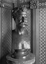 A bronze bust of Mark Twain on a pedestal