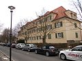 Two multi-family houses (No. 26/28 and No. 30) in a residential complex, with connecting gate passage, front gardens and bricked corner edging