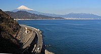 山域の南側の薩埵峠から望む駿河湾沿いの東海道本線、国道1号、東名高速道路と富士山