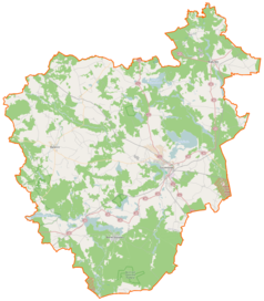 Mapa konturowa powiatu szczecineckiego, na dole po lewej znajduje się owalna plamka nieco zaostrzona i wystająca na lewo w swoim dolnym rogu z opisem „Komorze”