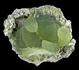 Water green color spheres of crystallized prehnite with minor calcite on basalt