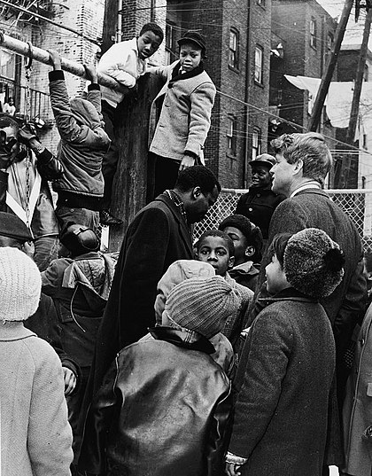 Kennedy (right) speaks with children while touring Bedford–Stuyvesant in Brooklyn, February 1966