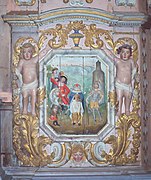 The martyrdom of St. Miliau, who holds his severed head as blood gushes from his neck. Retable of the Passion at Lampaul-Guimiliau.