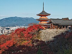 The three-tiered pagoda and the vibrant autumn foliage in Kiyomizu-dera, Kyoto.