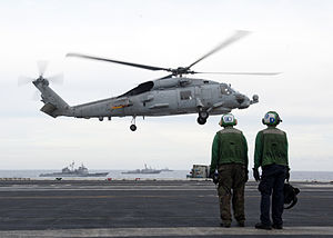 US Navy 120123-N-JL826-019 Sailors from the aircraft carrier USS Enterprise (CVN 65) stand by as an SH-60B Sea Hawk helicopter takes off during a n.jpg