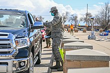US airman providing curbside service at Hill Air Force Base shopping center during the coronavirus pandemic, March 23, 2020 US airman providing curbside service during the coronavirus pandemic in 2020.jpg