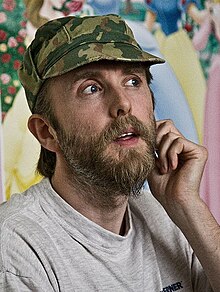 Varg Vikernes in his mid-thirties wearing a camouflage hat