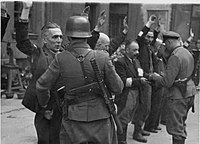 Германски войници претърсват евреи във Варшавското гето