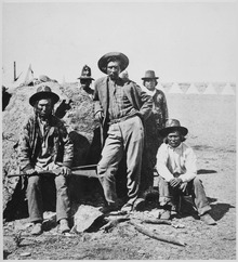 Warm Spring Indian scouts in the Lava Beds with their leader, Donald McKay, center Warm Spring scouts, Lava Beds, California, their leader, Donald McKay, is leaning against rock, 1873 - NARA - 533246.tif