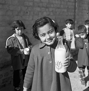 طفلة تحمل زجاجة حليب خلال فترة الاستراحة في إحدى مدارس بغداد، 1961.jpg