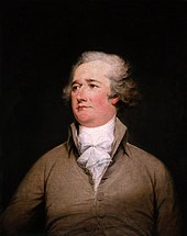 Der junge Alexander Hamilton in einem beigen Anzug mit aufgeklappten Kragen und einem weißen Halstuch.