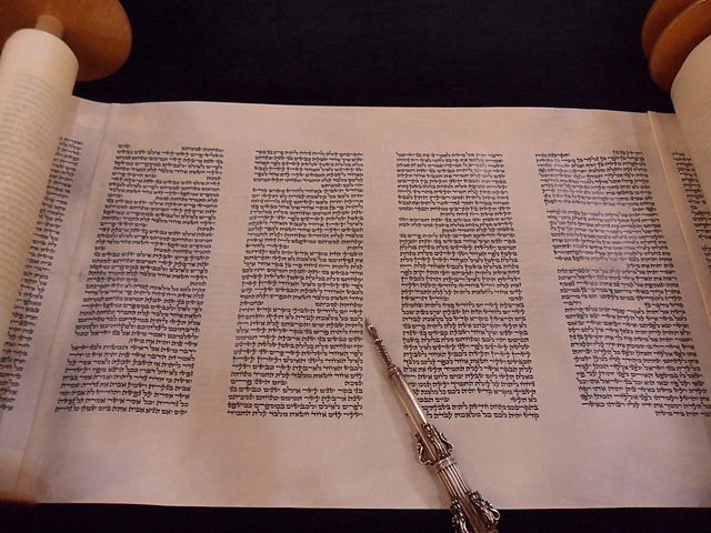 An opened Torah scroll (Book of Numbers part), and a reading pointer (yad).