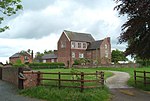 Bettisfield Hall Farm, with a house at the centre and a path towards it.