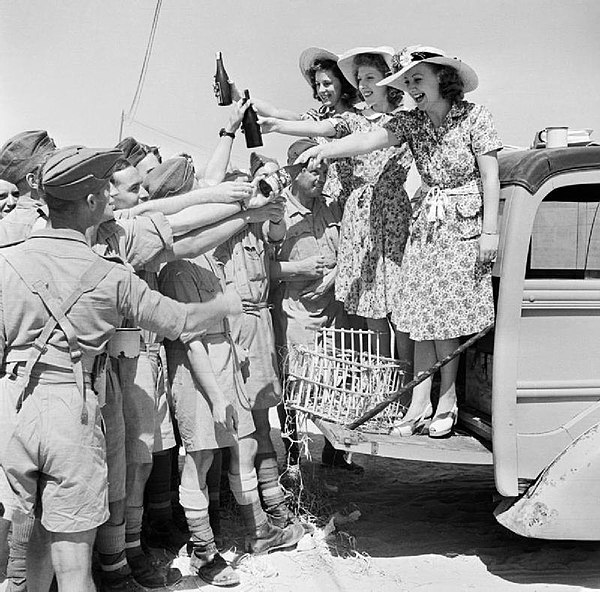 ENSA Glamour Girls distribute cigarettes and beer to troops in North Africa, 26 July 1942.
