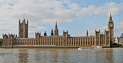 View of the long Parliament building, as seen from the southern bank of the Thames. On the left of the building is the Victoria Tower, flying the Union Flag; on the right is the Elizabeth Tower (often called Big Ben).