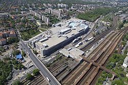 Előtérben a Kőbánya-Kispest vasútállomás, mögötte, már Kispesten a KöKi Terminál