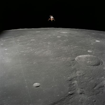Lunar Module Intrepid above the Moon. The small crater in the foreground is Ammonius; the large crater at right is Herschel. Photograph by Richard F. Gordon Jr. on board the Command Module Yankee Clipper.