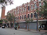 In 1903 William De Zwaan designed the Sammy Marks Building, this happened in the same time as the Tudor chambers on Church Square and the Saxon Chambers & the Afrik house in Paul Kruger Str. The shopfronts of this building reminds us of the Amsterdam 'gragtehuise'. In the North-western corner of the building, parts were removed to achieve installing underpinning bases in and outside of the gable wall as well as casting re-concrete into the wall, that was a highly complex process, completed without problems.[2]