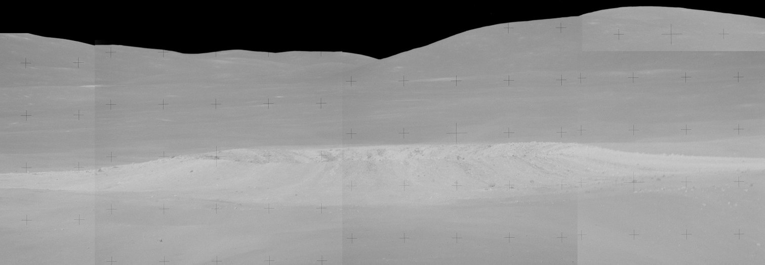 9° 09′ S, 15° 23′ E﻿ / ﻿9.15°S,15.38°E﻿ / -9.15; 15.38 Panorama de South Ray des de l'Estació 4 (cràter Cinc) a Stone Mountain, mirant al sud-oest. Charlie Duke va dir mentre prenia les fotografies d'aquesta panoràmica: «Puc veure la vora de la paret interior al costat sud. I les característiques de l'objecte: té ratlles negres i ratlles blanques sortint de la paret just sobre la vora, el que em diu que hi ha dos tipus de roques allà baix».[3]