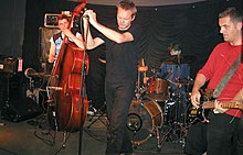 Turn is The Ex's sole studio album to feature contrabassist Rozemarie Heggen, pictured here with bandmates G.W. Sok, Katherina Bornefeld, and Andy Moor at a 2004 concert in Germany. TheEx June2004.jpg