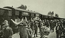 A Uganda Railway train carrying captured German war flags, 1914 The Times history of the war (1914) train with war trophies (ref Luvungi).jpg