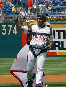 A United States Navy Parachute Team member lands on the field at Citizens Bank Park during the 2006 season. US Navy 060618-N-4729H-077 Leapfrogs, Navy Parachute Team member, Navy SEAL (Sea, Air and Land) Nix White, sports a Philadelphia Phillies' home uniform, as he lands on the baseball field during the pre-game show.jpg