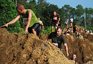 US Navy 100918-N-7084M-405 Participants in the 15th Annual Seabee Volkslauf Mud Run make their way over a obstacle in the five-mile course at Naval.jpg