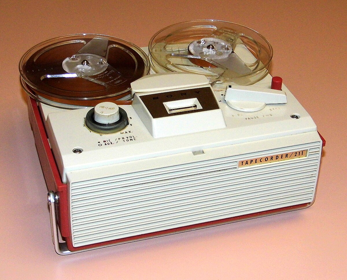 https://upload.wikimedia.org/wikipedia/commons/thumb/c/ca/Vintage_Sony_Reel-To-Reel_Portable_Tape_Recorder%2C_Model_TC-211%2C_AC_Operation_Only%2C_Made_In_Japan%2C_Circa_1960s_%2832061047370%29.jpg/1200px-Vintage_Sony_Reel-To-Reel_Portable_Tape_Recorder%2C_Model_TC-211%2C_AC_Operation_Only%2C_Made_In_Japan%2C_Circa_1960s_%2832061047370%29.jpg