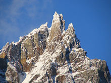 Hoher schroffer Berg, leicht mit Schnee bedeckt.