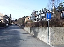 Foto einer Straße, gesäumt von Häusern mit Garten