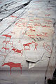 Détails des gravures rupestres : de la peinture rouge a été appliquée dans un but didactique pour souligner les symboles mais n'existait pas à l'origine. Ces peintures sont progressivement retirées.