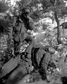 A US soldier examines a dead Chinese soldier killed during the offensive drive of the 5th RCT near the Han River area, Korea DeadChinesesoldier2.JPG