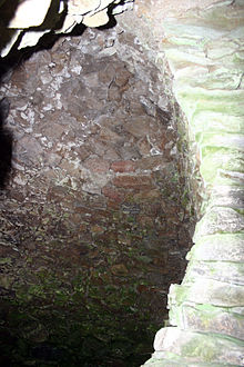 Zenith Flachwinkelansicht eines Kraggewölbes.  Rechts eine Stützmauer.