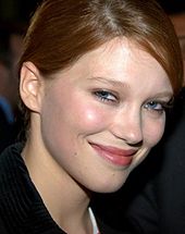 Photographie au format portrait d'une jeune femme blonde souriante.