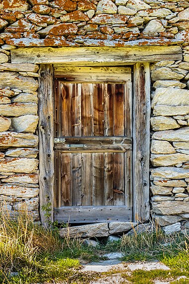 Porta de uma cabana perto do passo do Lukmanier, cantão dos Grisões, Suíça. Lukmanier é um passo alpino ligando o braço oriental do vale de Blenio (vale de Santa Maria, atravessado pelo rio Brenno) com o vale de Medel. Do ponto de vista orográfico, o passo de montanha está localizado na seção alpina dos Alpes Lepontinos e separa os Alpes do Monte Leone e do São Gotardo (a oeste) dos Alpes da Adula (a leste). (definição 3 217 × 3 217)