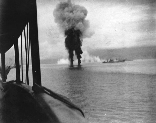 Smoke rises from two Japanese aircraft shot down off Guadalcanal on 12 November 1942; ship at right is USS Betelgeuse