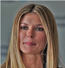 Blonde woman smiling while standing in a public lounge