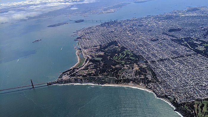 Aerial view of the Presidio from outside the Golden Gate, with downtown and Bay Bridge in the background